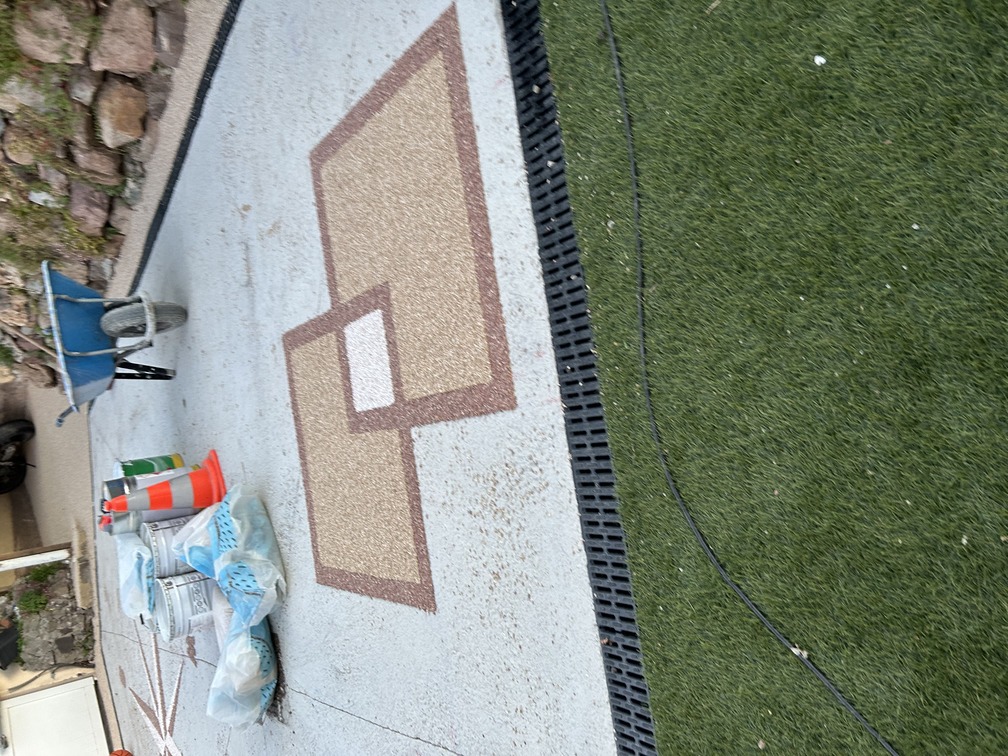 Zoom sur dessin décoratif personnalisé en résine gravillonnée sur béton de résidence de particulier