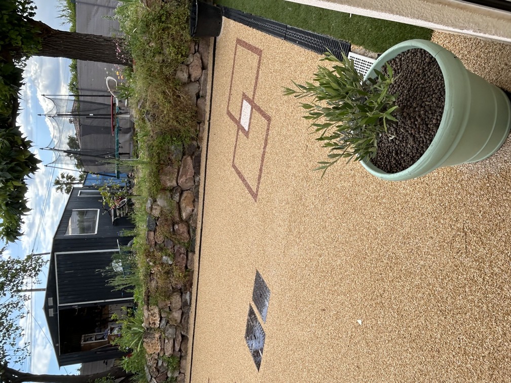 Marquage dessin décoratif personnalisé en résine gravillonnée sur béton de résidence de particulier